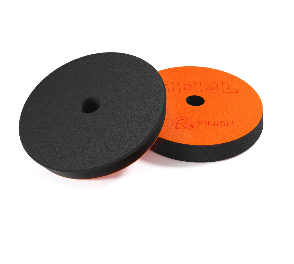 Two polisher pads, one black and one orange with ADBL branding, on a white background.
